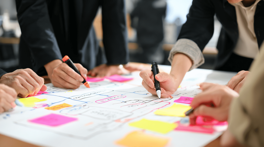 Equipo de trabajo dibujando un flujograma con post-its para definir el diseño de procesos de la organizacion