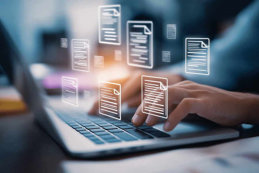 Persona usando una laptop con iconos de archivos y documentos en pantalla, asociada a gestion documental